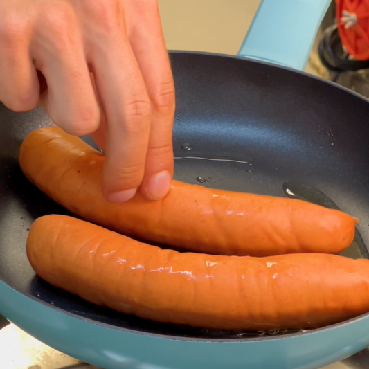Hot dog de bratwurst con salsa de queso, kétchup y mostaza